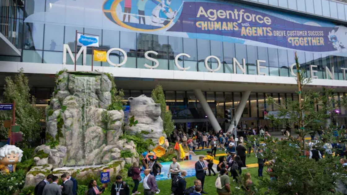 Attendees gather in Dreamforce's Campground area outside Moscone Center, with a rock-and-waterfall display and an Agentforce banner above the entrance.