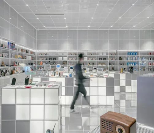 A shopper walking through a brightly lit retail store lined with product displays