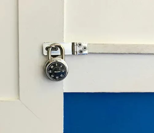 A padlock securing a door latch.