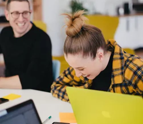 Two colleagues reviewing customer data together on a laptop